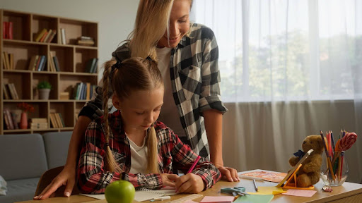 A woman helps her daughter with homework during her parenting time schedule