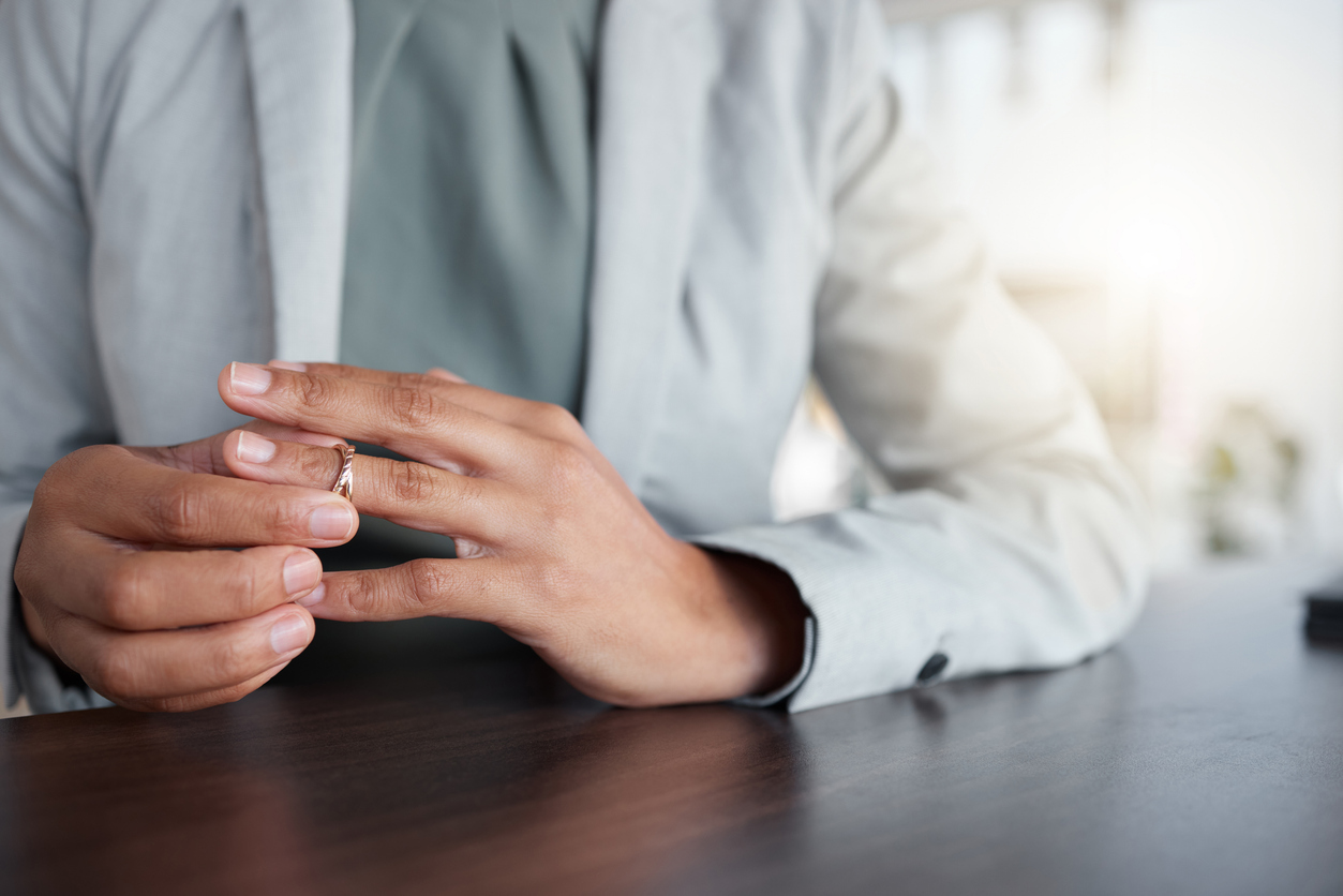 A divorcee removes the wedding ring from her finger