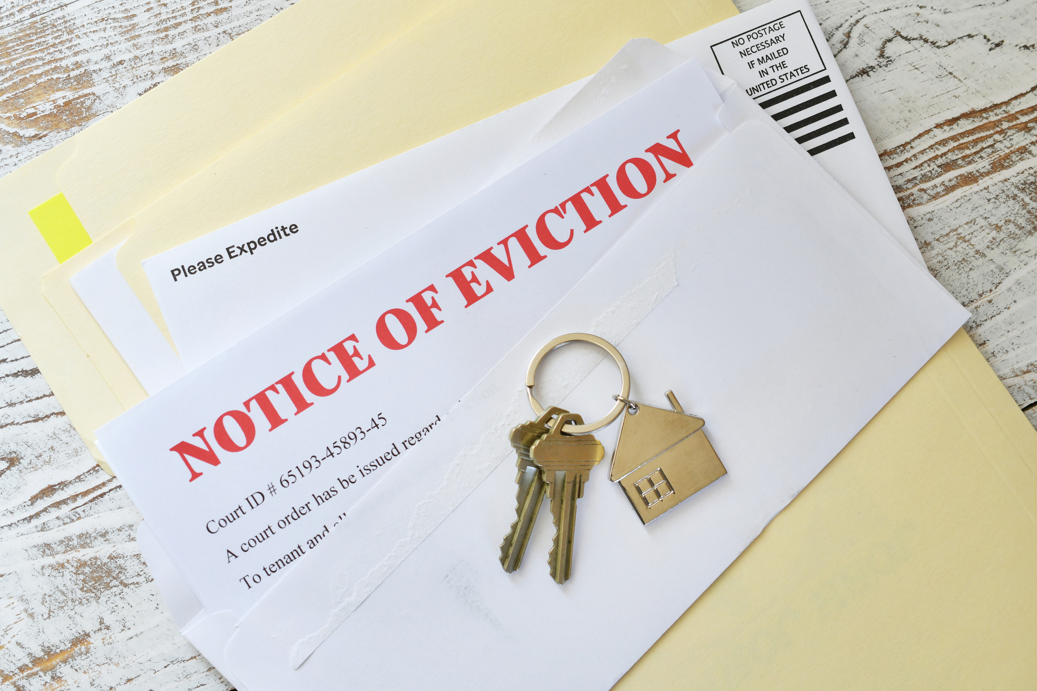 An eviction notice received through the mail is pictured with a set of keys. 